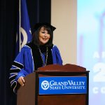 President Philomena Mantella behind podium in regalia
